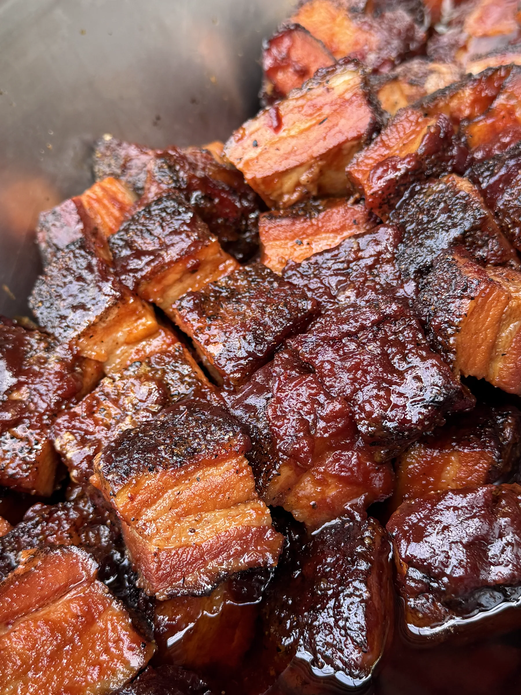 Κοντινό πλάνο από καπνιστά κομμάτια pork belly με γυαλιστερή κρούστα.